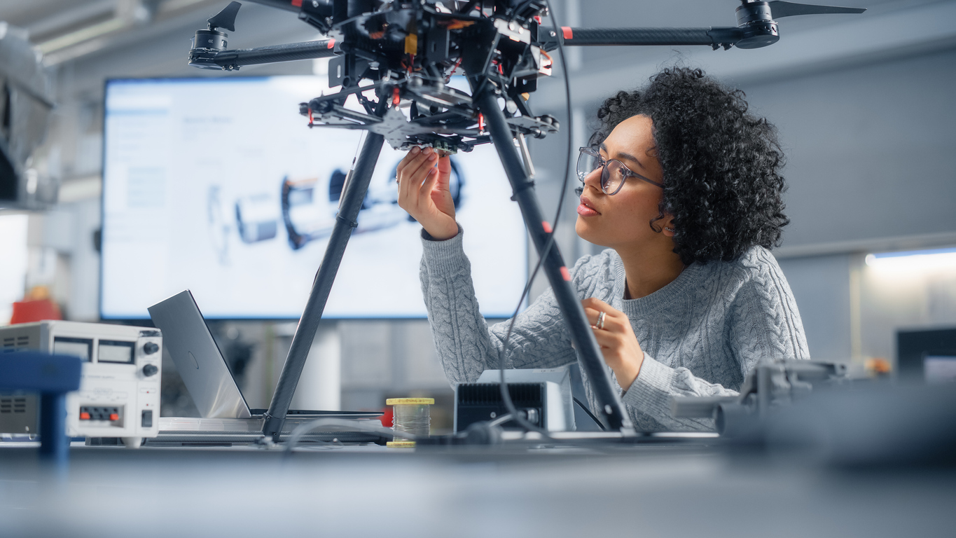 A female research technical professional works on equipment as part of a research project, in a lab.
